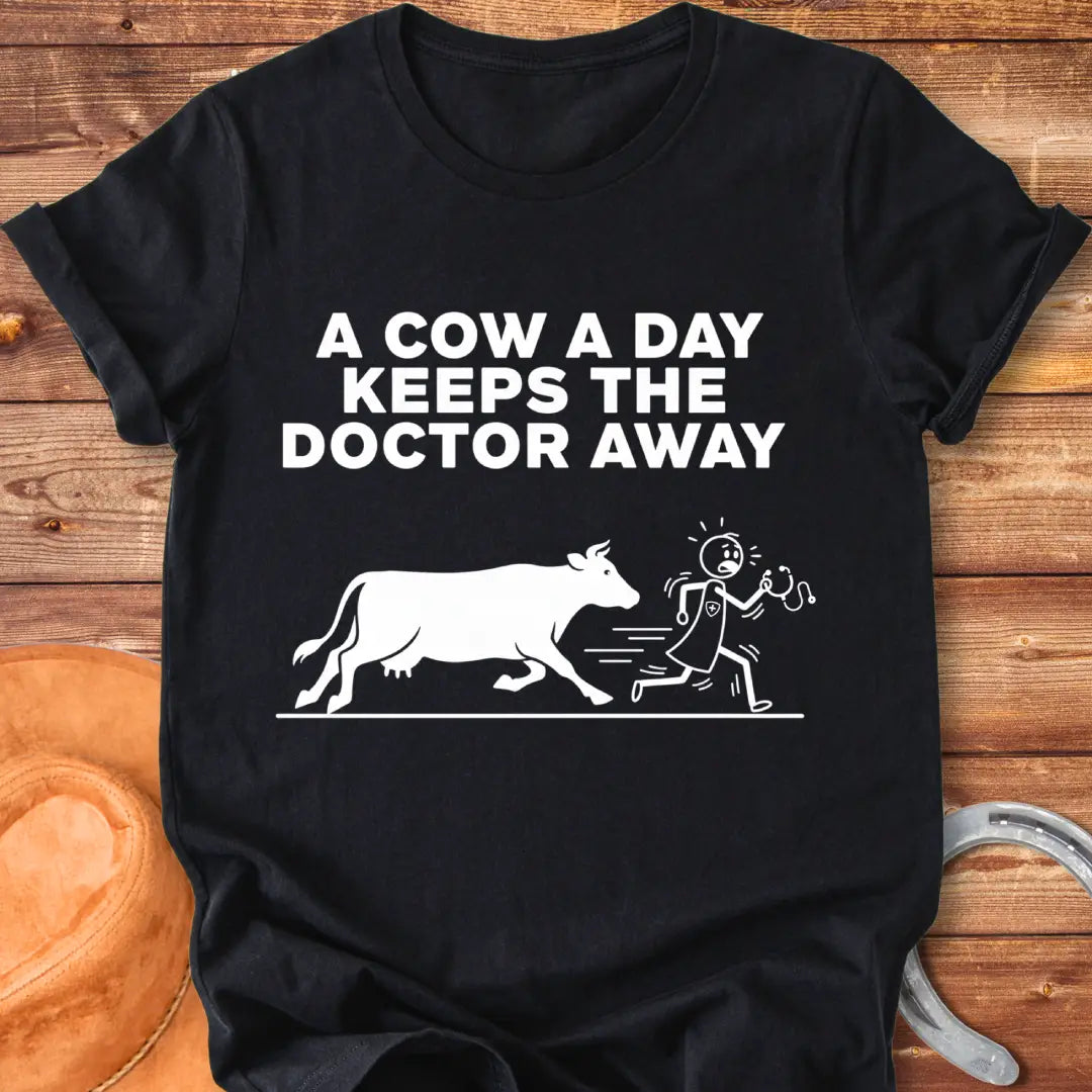 Black t-shirt design with a cow illustration and the text 'A Cow a Day Keeps the Doctor Away'