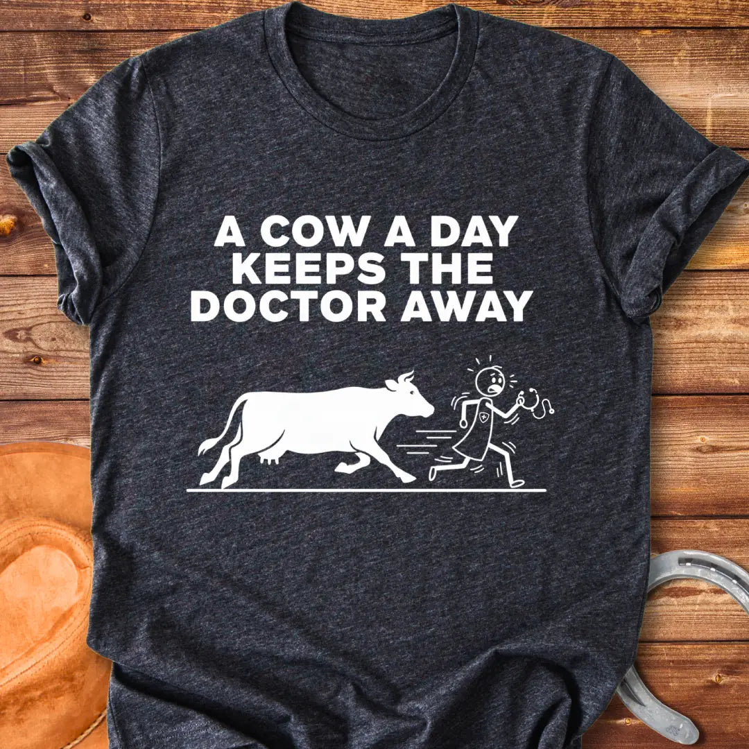 Black t-shirt design with a cow illustration and the text 'A Cow a Day Keeps the Doctor Away'