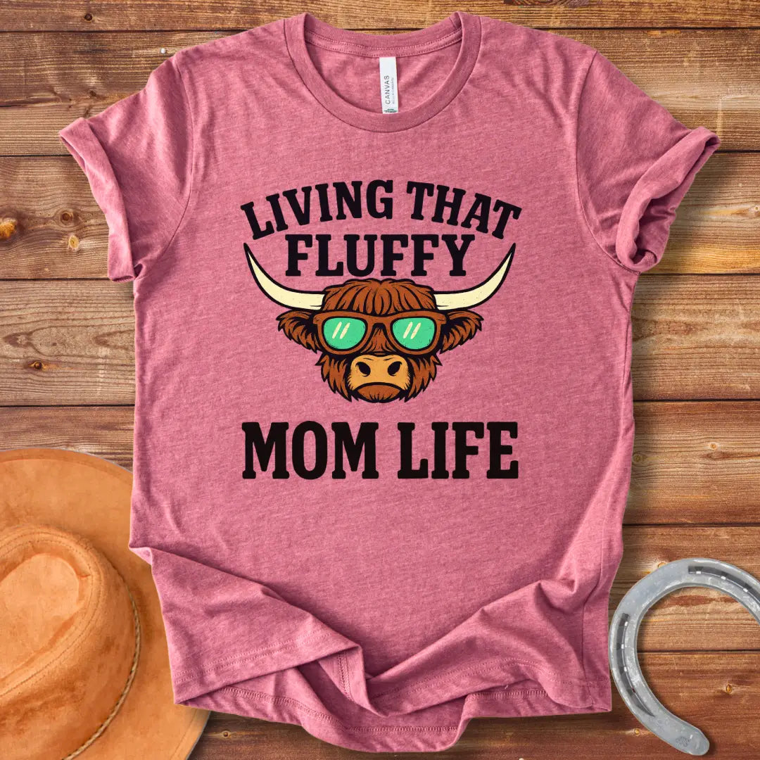A graphic of a Highland cow wearing sunglasses with the text 'Living That Fluffy Mom Life' above and below it.