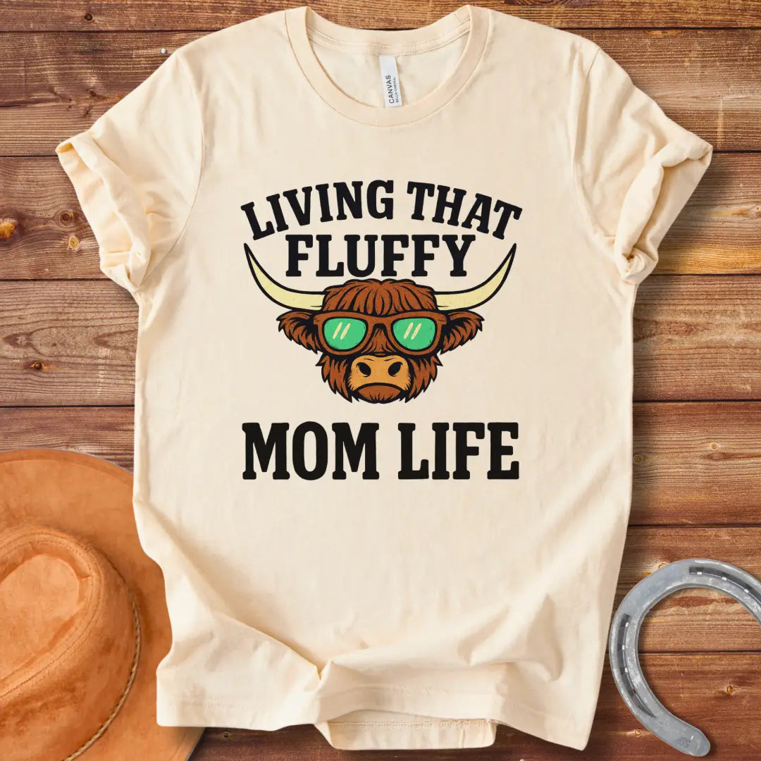 A graphic of a Highland cow wearing sunglasses with the text 'Living That Fluffy Mom Life' above and below it.
