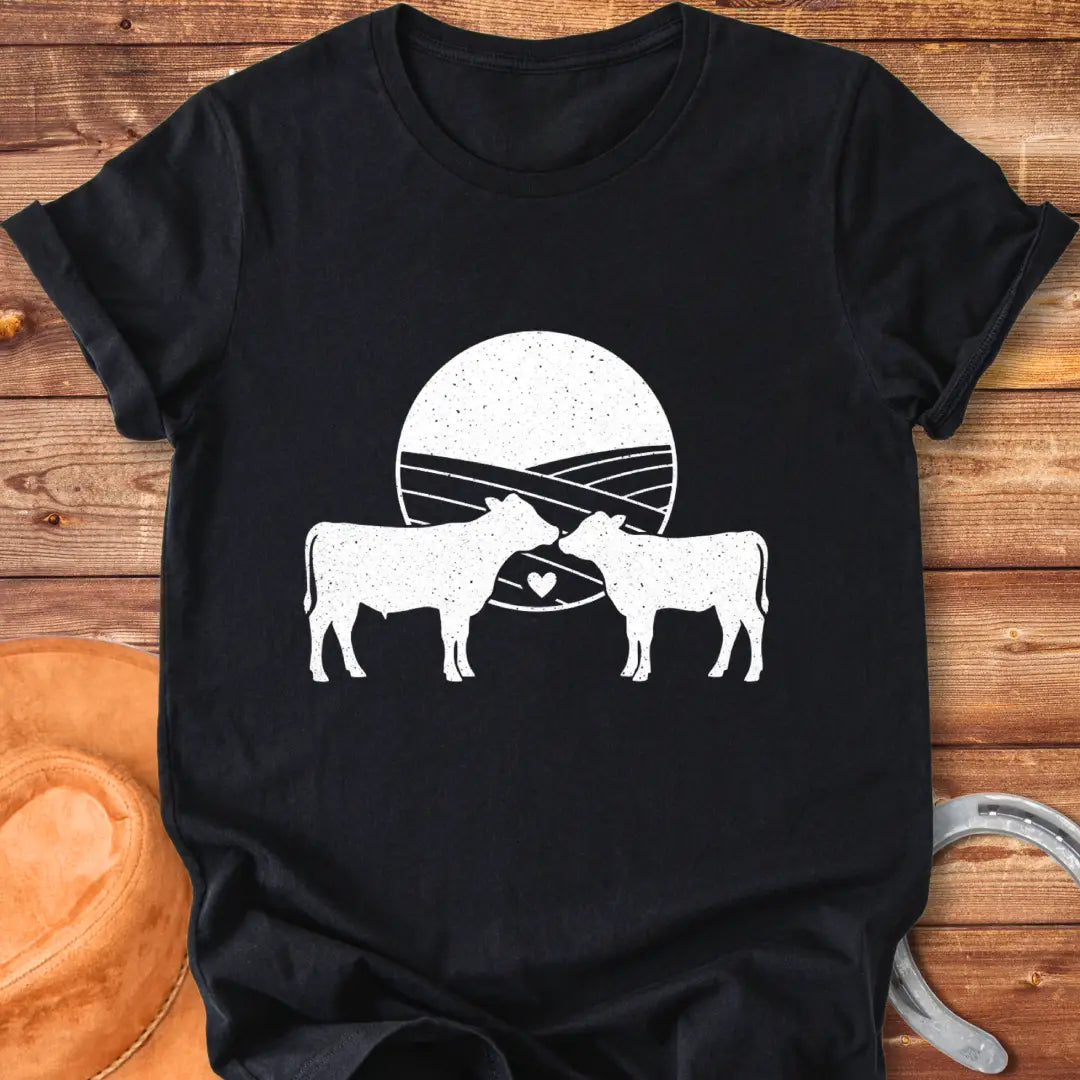 Silhouette of a mother cow and her calf, with a heart in between them and a field background