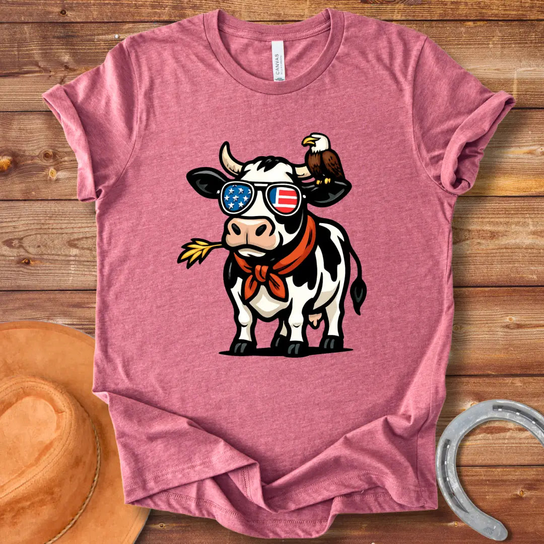 Patriotic cow wearing sunglasses with American flag design and an eagle on its head, a red bandana, and a wheat in its mouth, 'MERICA Moo T-Shirt'