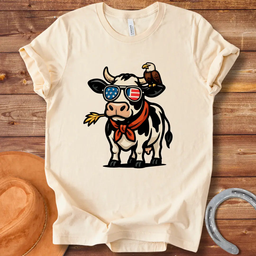Patriotic cow wearing sunglasses with American flag design and an eagle on its head, a red bandana, and a wheat in its mouth, 'MERICA Moo T-Shirt'