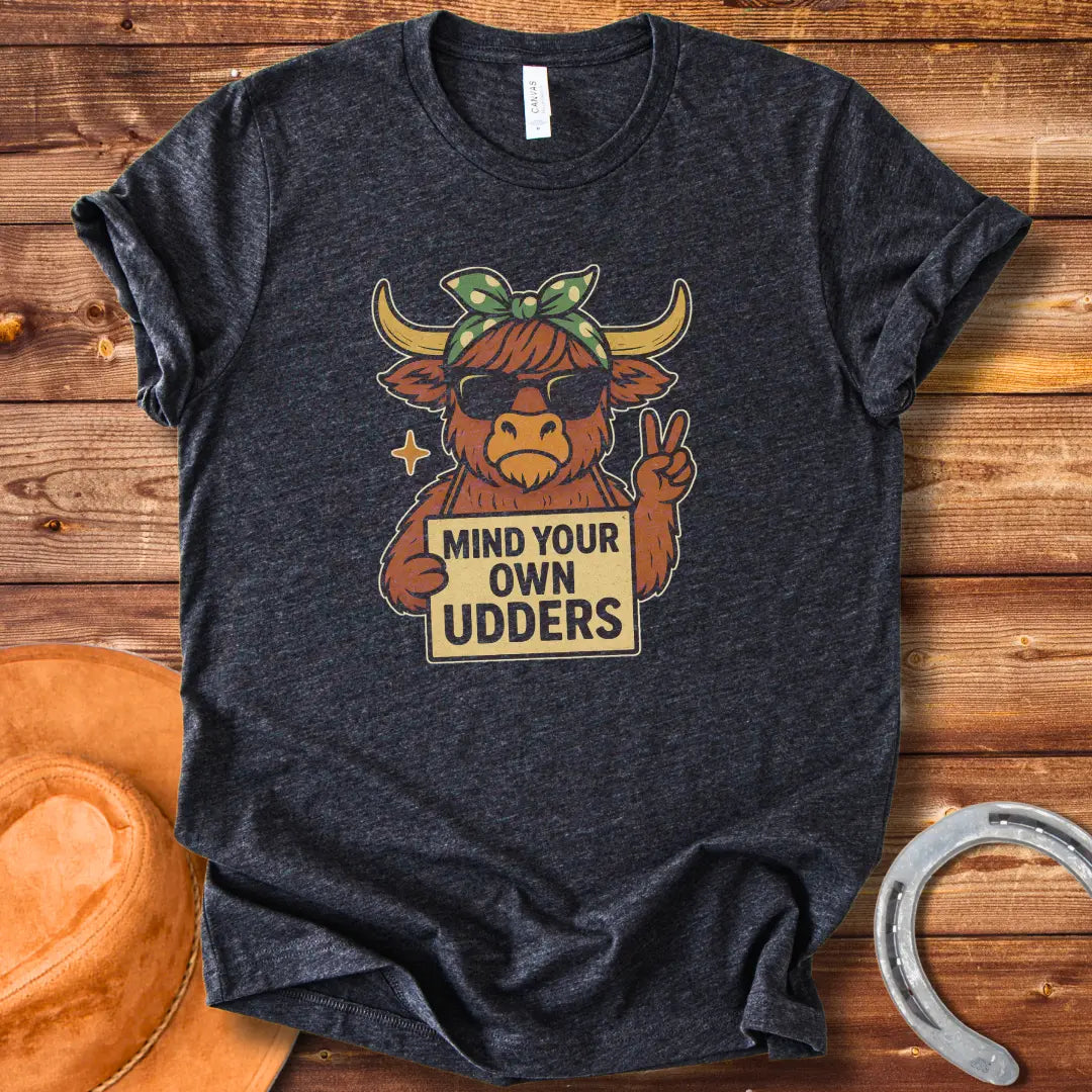Illustration of a cool cow wearing sunglasses and a bandana, holding a sign that says 'Mind Your Own Udders' and giving a peace sign.