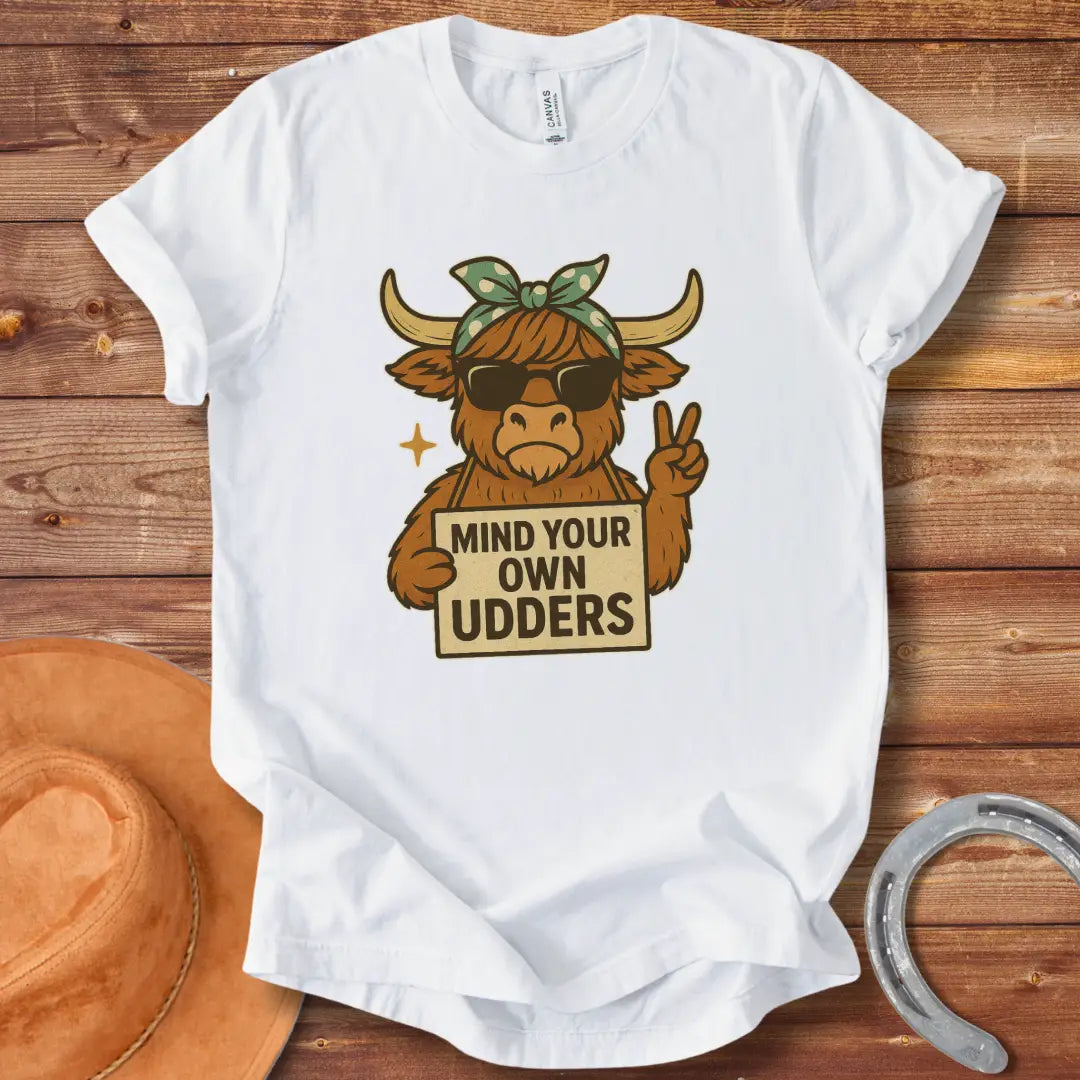 Illustration of a cool cow wearing sunglasses and a bandana, holding a sign that says 'Mind Your Own Udders' and giving a peace sign.