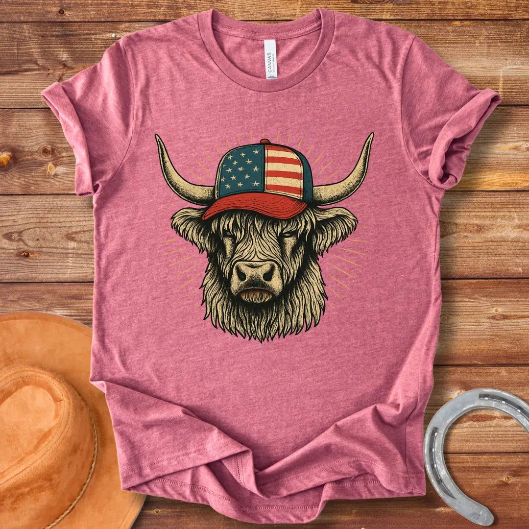 Illustration of a Highland cow wearing an American flag baseball cap, with sun rays emanating from behind the cow's head.