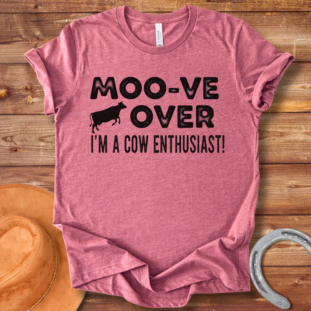 A black and white graphic tee design that says 'Moo-ve Over' with a silhouette of a cow and 'I'm a Cow Enthusiast!' below.