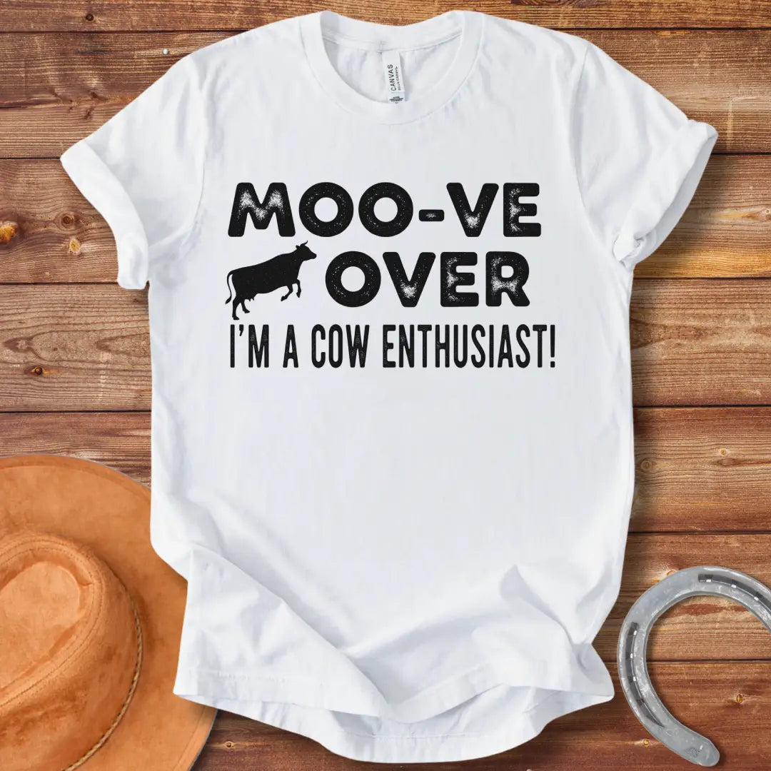 A black and white graphic tee design that says 'Moo-ve Over' with a silhouette of a cow and 'I'm a Cow Enthusiast!' below.