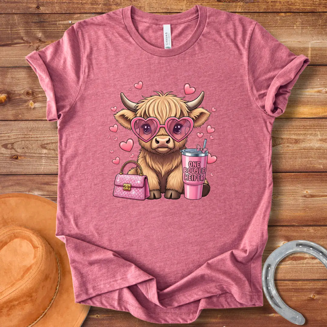 Illustration of a fluffy cow wearing heart-shaped sunglasses and holding a pink drink and purse that says 'One Boujee Heifer' with pink hearts surrounding it.