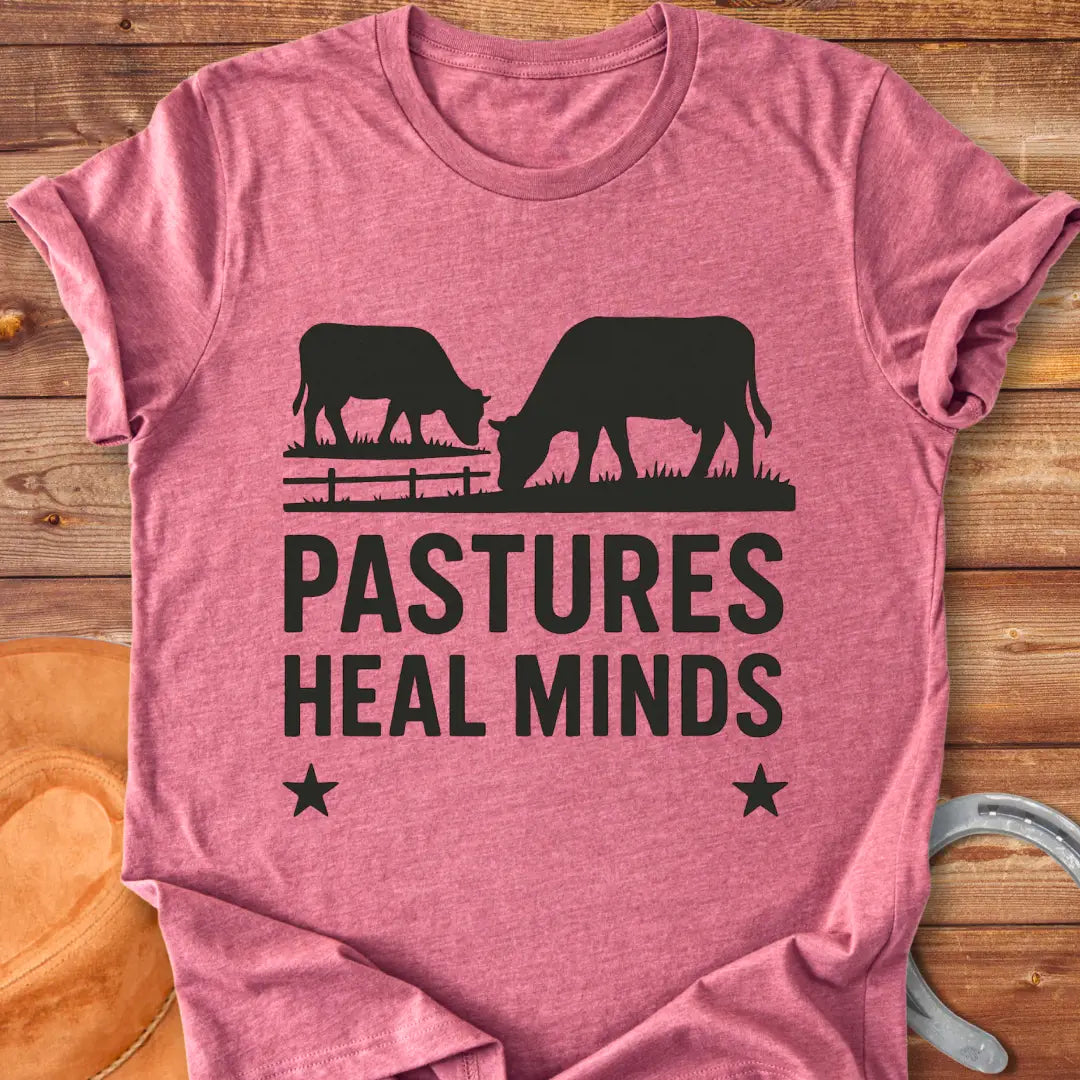 Two cows grazing in a pasture with the text 'Pastures Heal Minds' in a unique design.