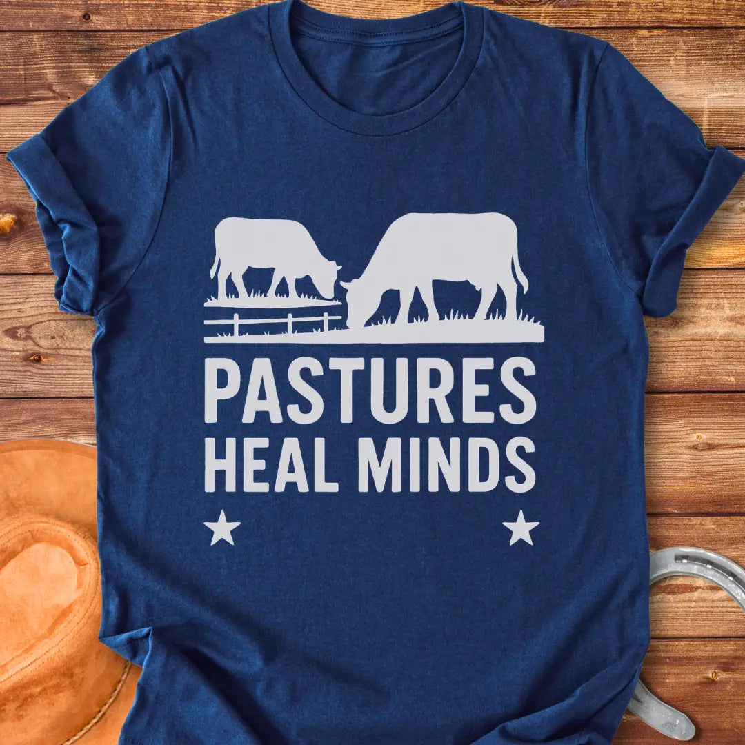 Two cows grazing in a pasture with the text 'Pastures Heal Minds' in a unique design.