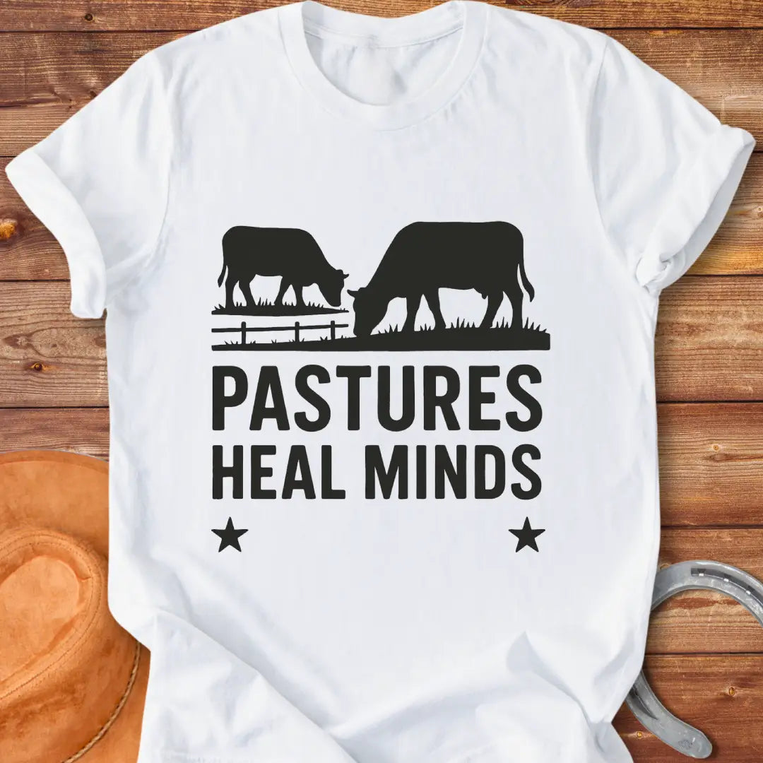 Two cows grazing in a pasture with the text 'Pastures Heal Minds' in a unique design.