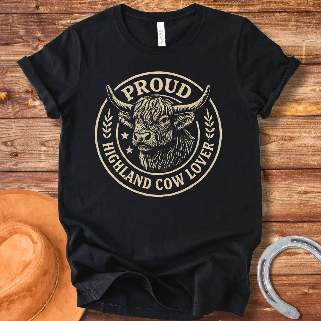 Proud Highland Cow Lover T-Shirt featuring a detailed illustration of a Highland cow's head and the text 'Proud Highland Cow Lover' in a circular design.
