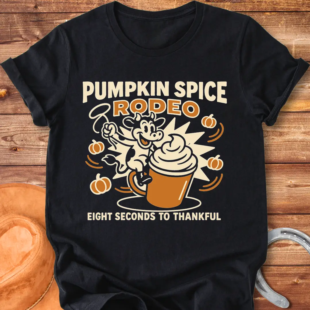 Pumpkin Spice Rodeo T-Shirt featuring a cow riding a pumpkin spice latte, with pumpkins in the background.