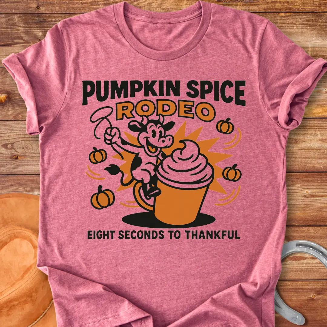 Pumpkin Spice Rodeo T-Shirt featuring a cow riding a pumpkin spice latte, with pumpkins in the background.