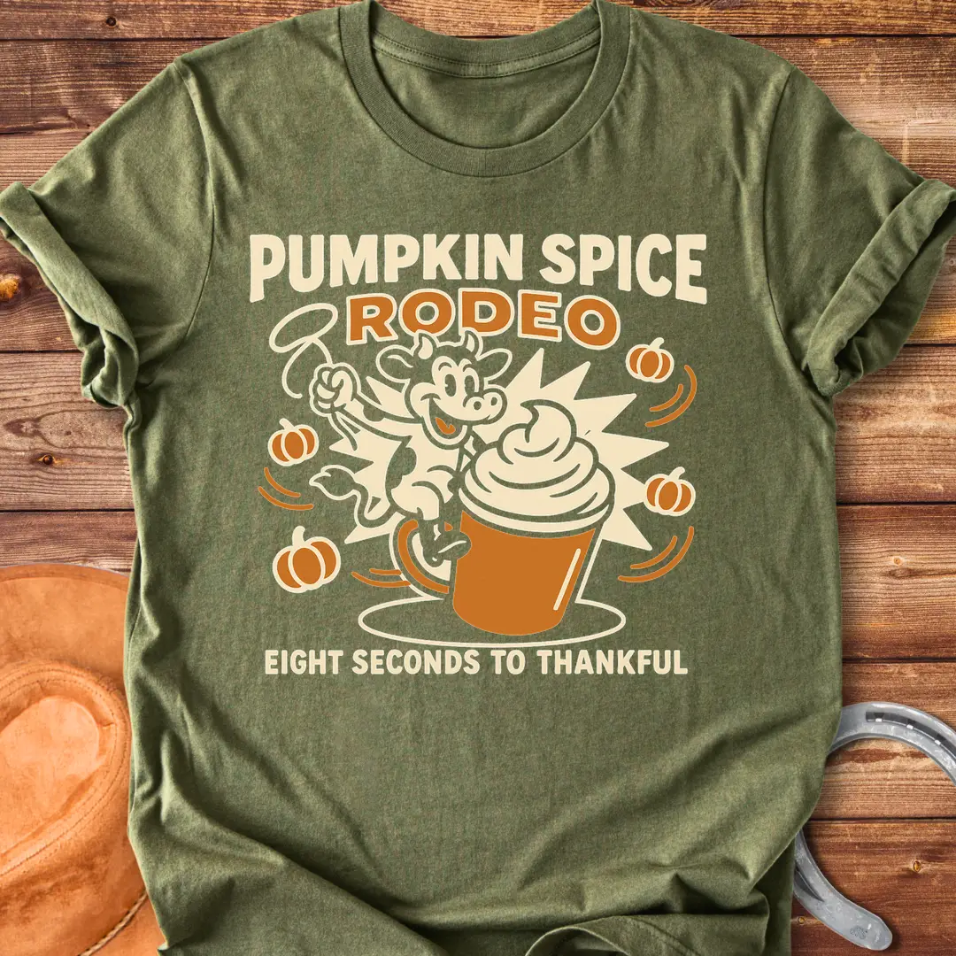 Pumpkin Spice Rodeo T-Shirt featuring a cow riding a pumpkin spice latte, with pumpkins in the background.