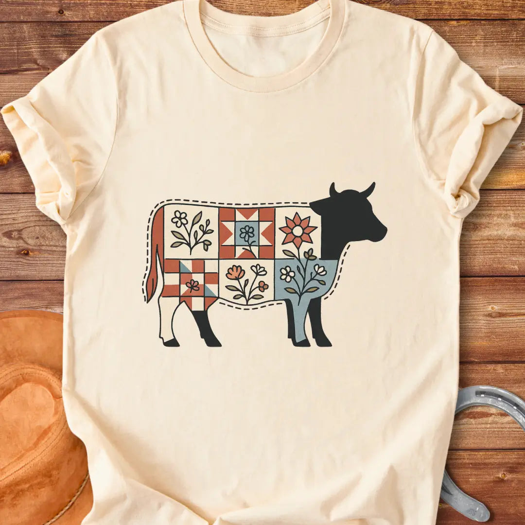 Quilt Blooms T-Shirt featuring a cow silhouette with a patchwork quilt pattern and floral details.