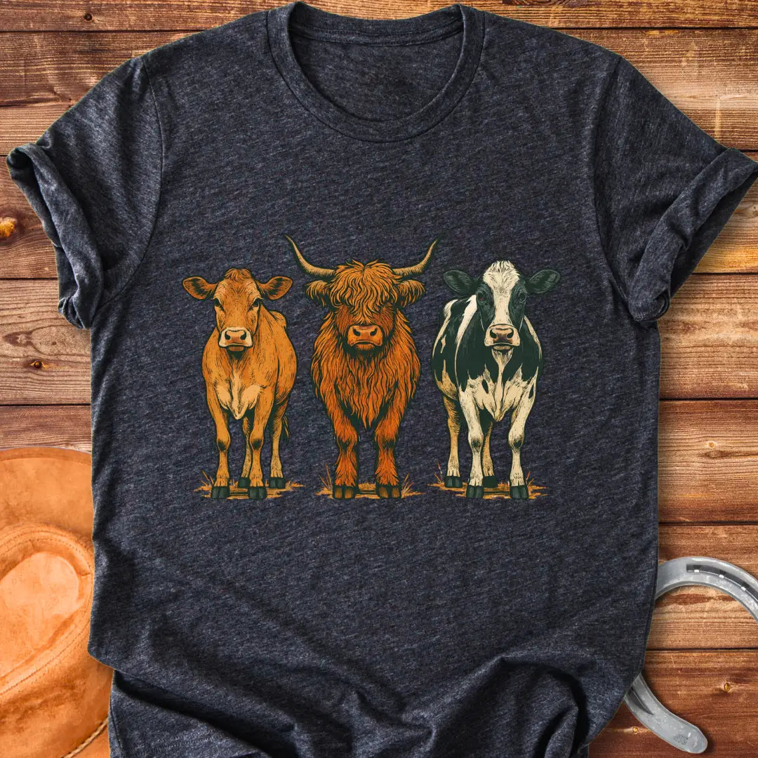 Rustic art t-shirt featuring three different cow breeds: a brown cow, a Highland cow, and a black and white cow.