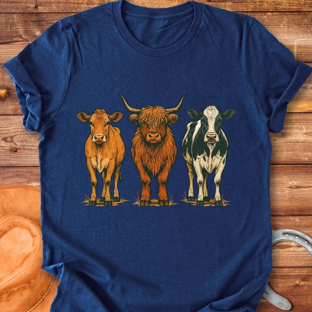 Rustic art t-shirt featuring three different cow breeds: a brown cow, a Highland cow, and a black and white cow.