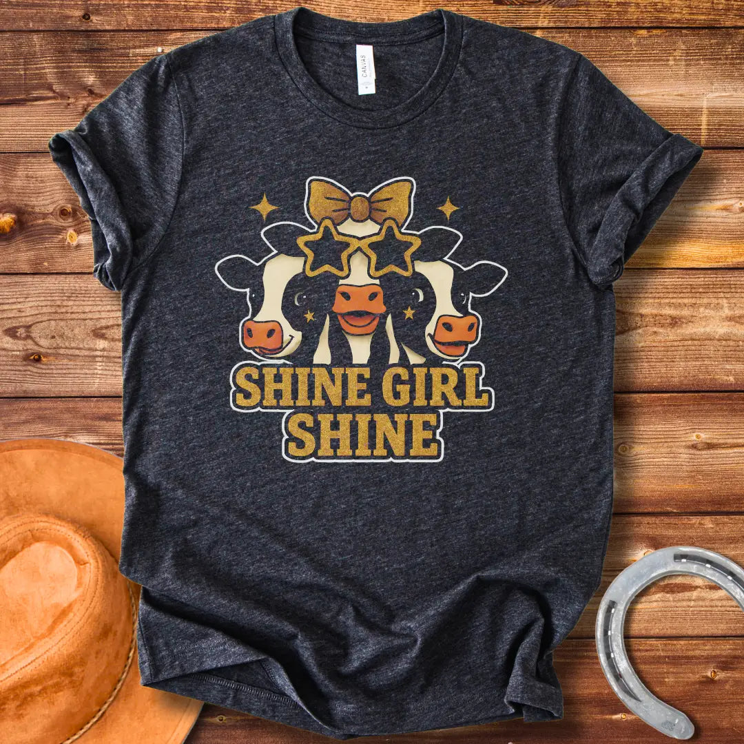Shine Girl Shine t-shirt featuring three cute cow faces wearing star-shaped sunglasses and gold accents, perfect for cow lovers.
