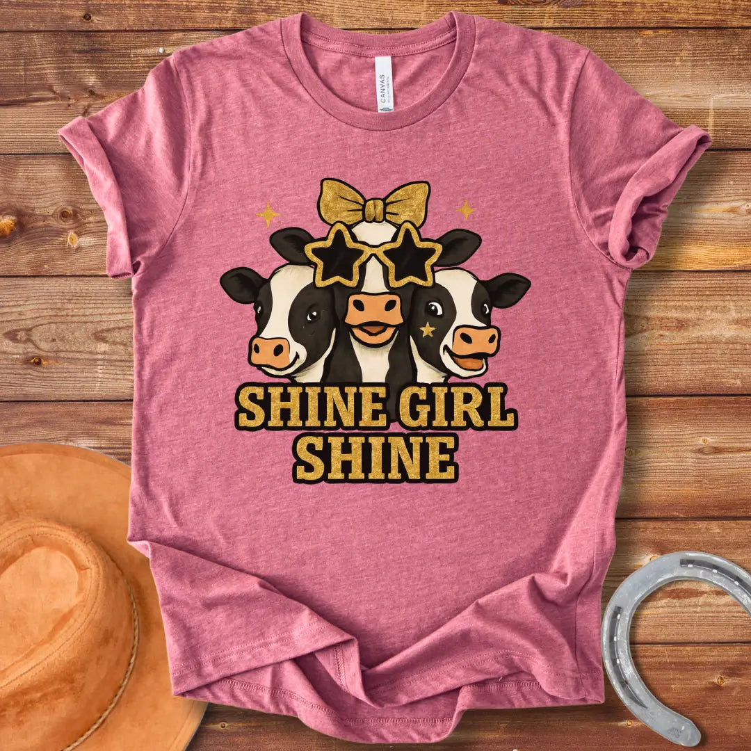 Shine Girl Shine t-shirt featuring three cute cow faces wearing star-shaped sunglasses and gold accents, perfect for cow lovers.