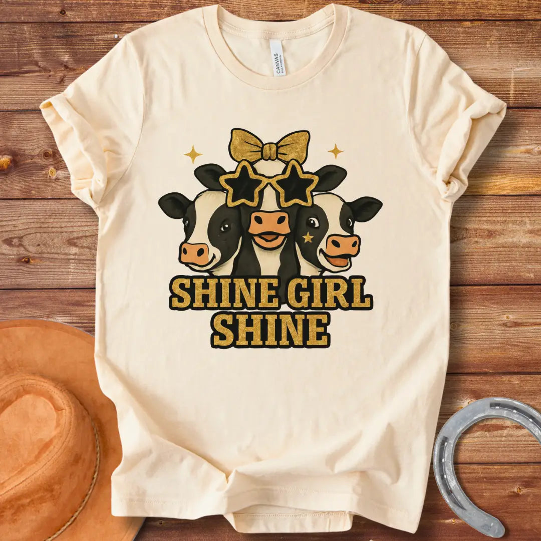 Shine Girl Shine t-shirt featuring three cute cow faces wearing star-shaped sunglasses and gold accents, perfect for cow lovers.