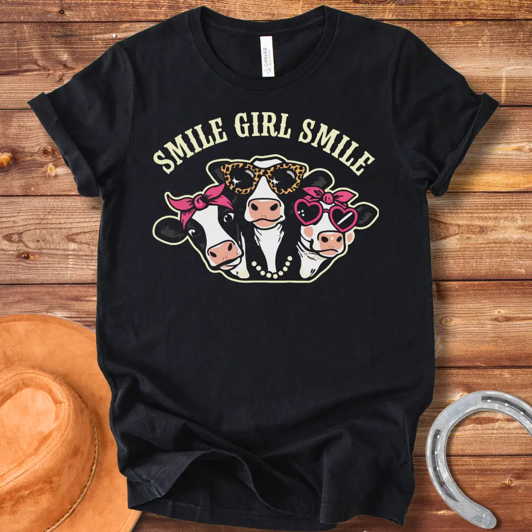 T-shirt featuring three smiling cows wearing sunglasses, bandanas, and pearls with the text 'Smile Girl Smile'