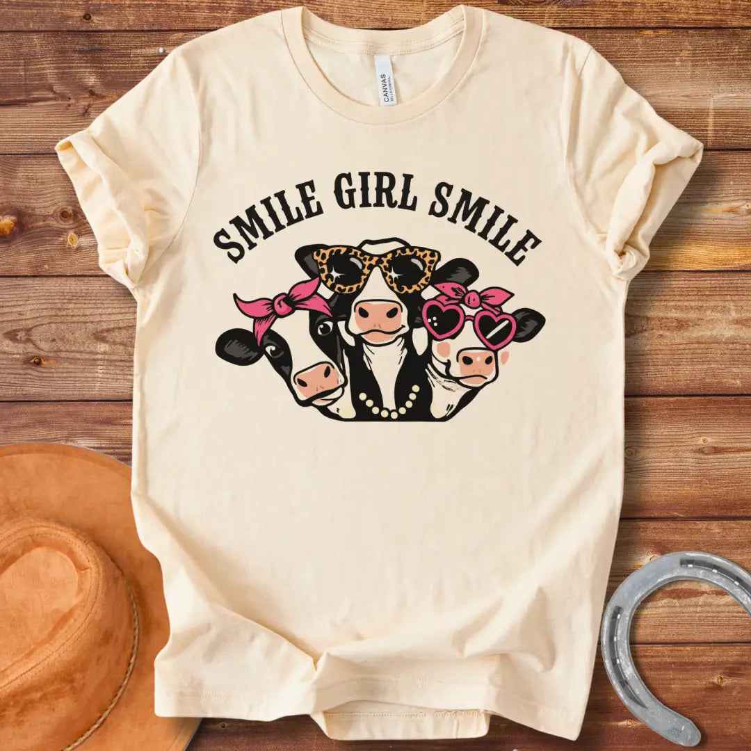 T-shirt featuring three smiling cows wearing sunglasses, bandanas, and pearls with the text 'Smile Girl Smile'