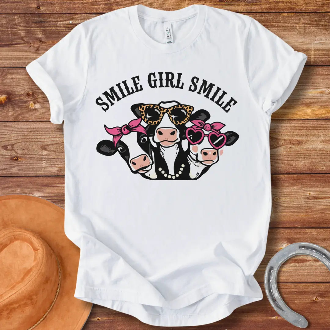 T-shirt featuring three smiling cows wearing sunglasses, bandanas, and pearls with the text 'Smile Girl Smile'
