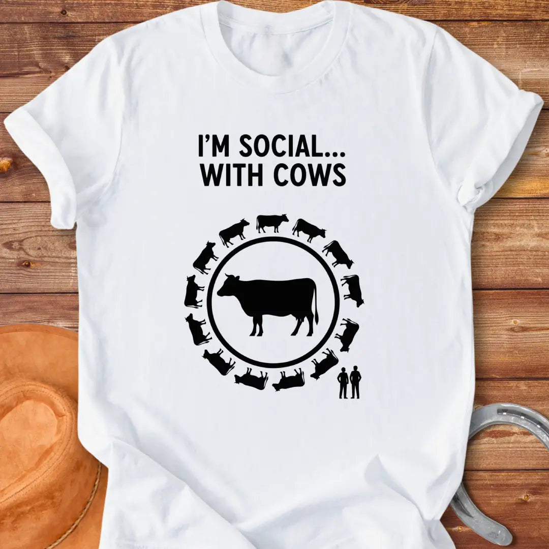 Black and white t-shirt design featuring a cow surrounded by smaller cow silhouettes with the words 'I'm social... with cows' above.