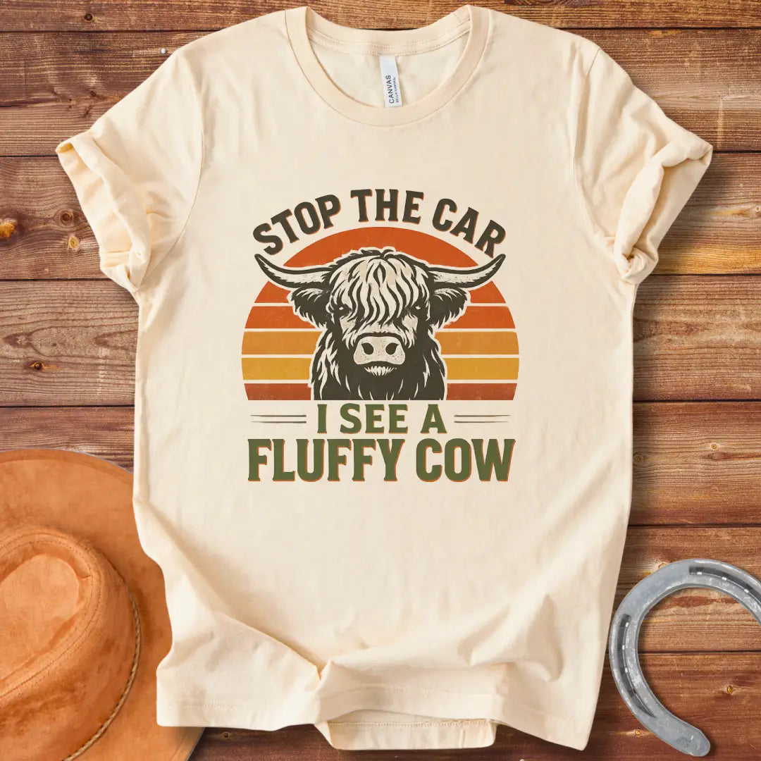 Vintage-style t-shirt design with a fluffy cow, the text 'Stop the Car, I see a Fluffy Cow' in a retro design.