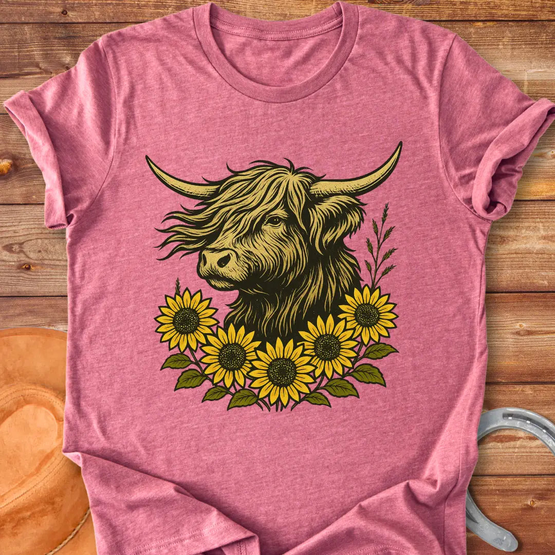 Sunflower fringe Highland cow t-shirt design, featuring a golden colored Highland cow head surrounded by vibrant sunflowers on a black background