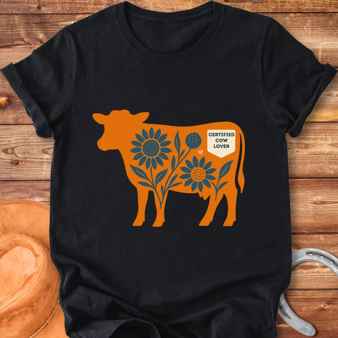 Sunflower Stockyard T-Shirt featuring an orange cow silhouette filled with blue sunflowers, a floral design, and a Certified Cow Lover badge.