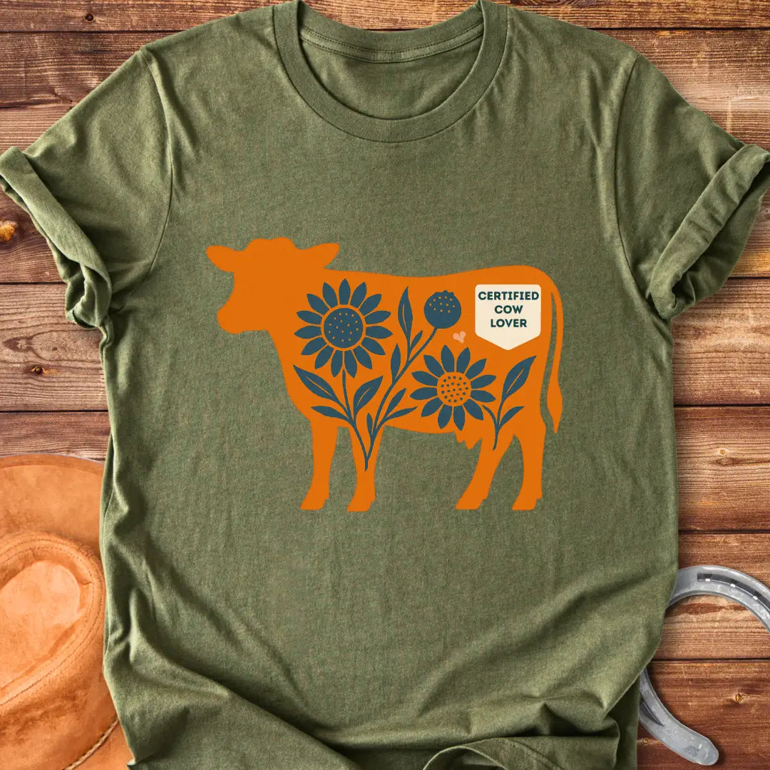 Sunflower Stockyard T-Shirt featuring an orange cow silhouette filled with blue sunflowers, a floral design, and a Certified Cow Lover badge.
