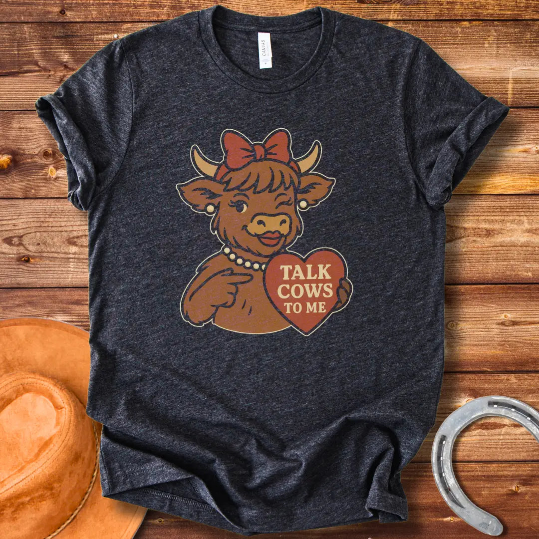 Charming cow wearing a bow and pearl necklace, holding a heart-shaped sign that says 'Talk Cows To Me'