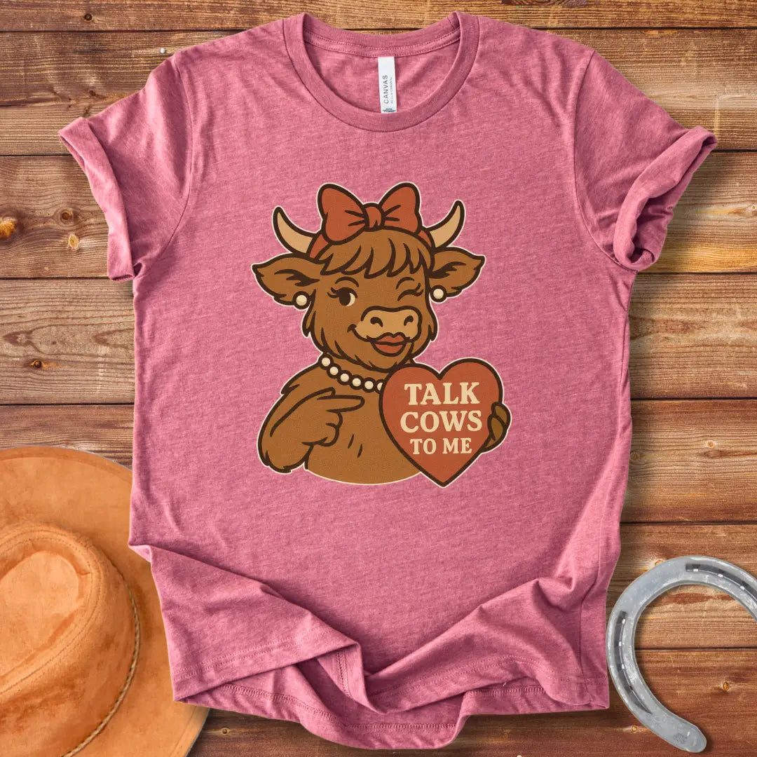 Charming cow wearing a bow and pearl necklace, holding a heart-shaped sign that says 'Talk Cows To Me'