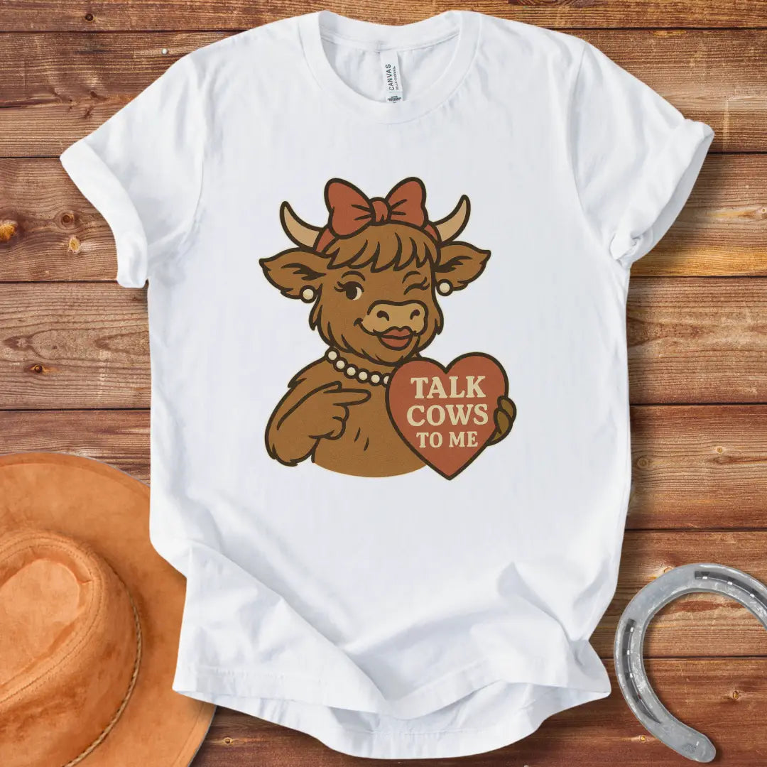 Charming cow wearing a bow and pearl necklace, holding a heart-shaped sign that says 'Talk Cows To Me'