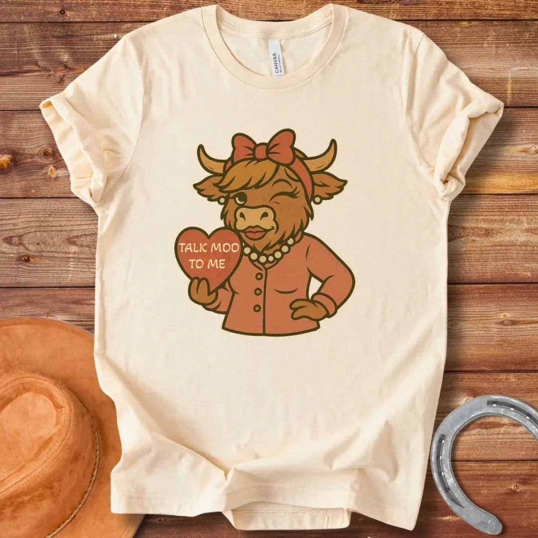 Talk Moo To Me T-Shirt design featuring a stylish winking cow holding a heart