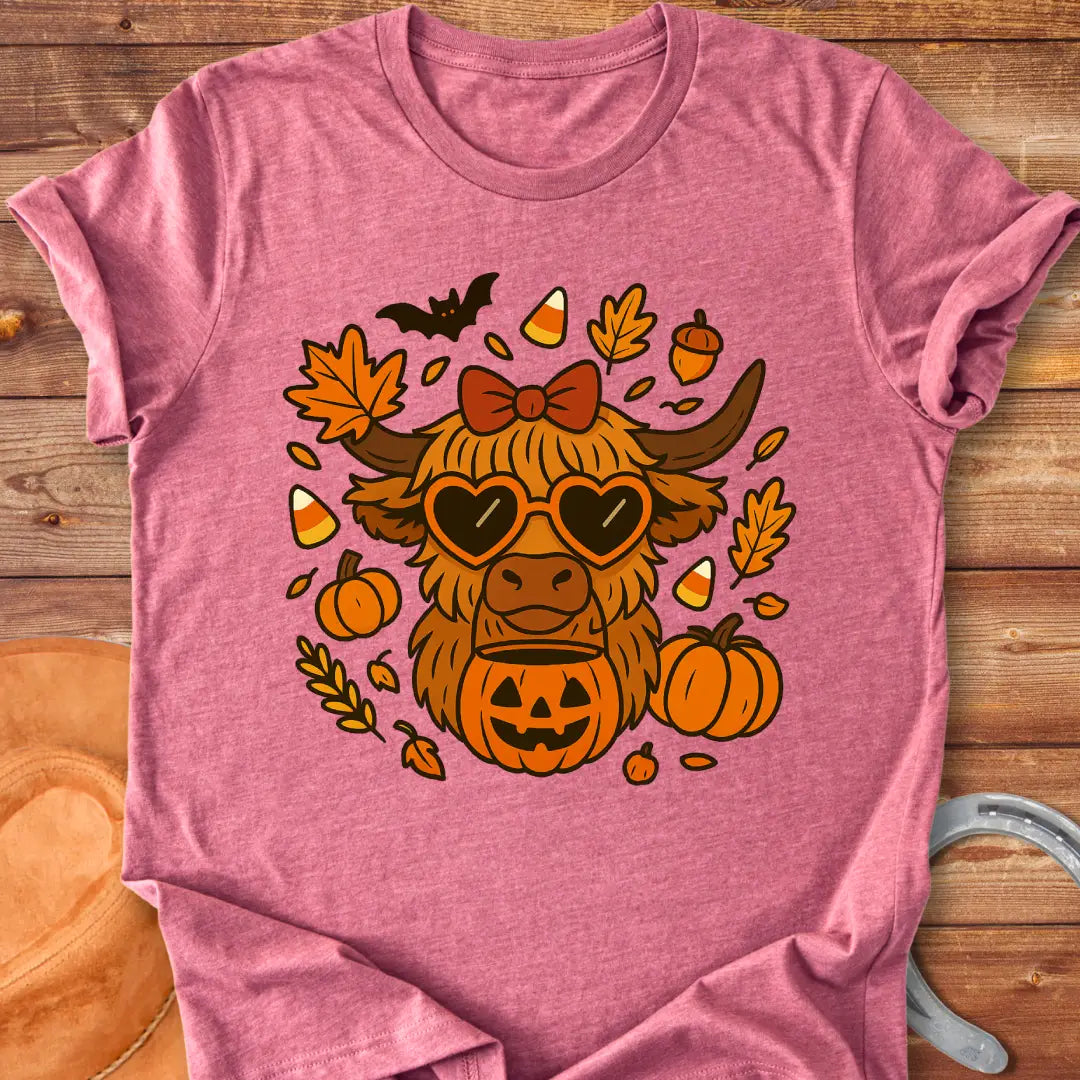 Trick or Treat Halloween Highland Cow T-Shirt design featuring pumpkins, leaves, and heart-shaped glasses.