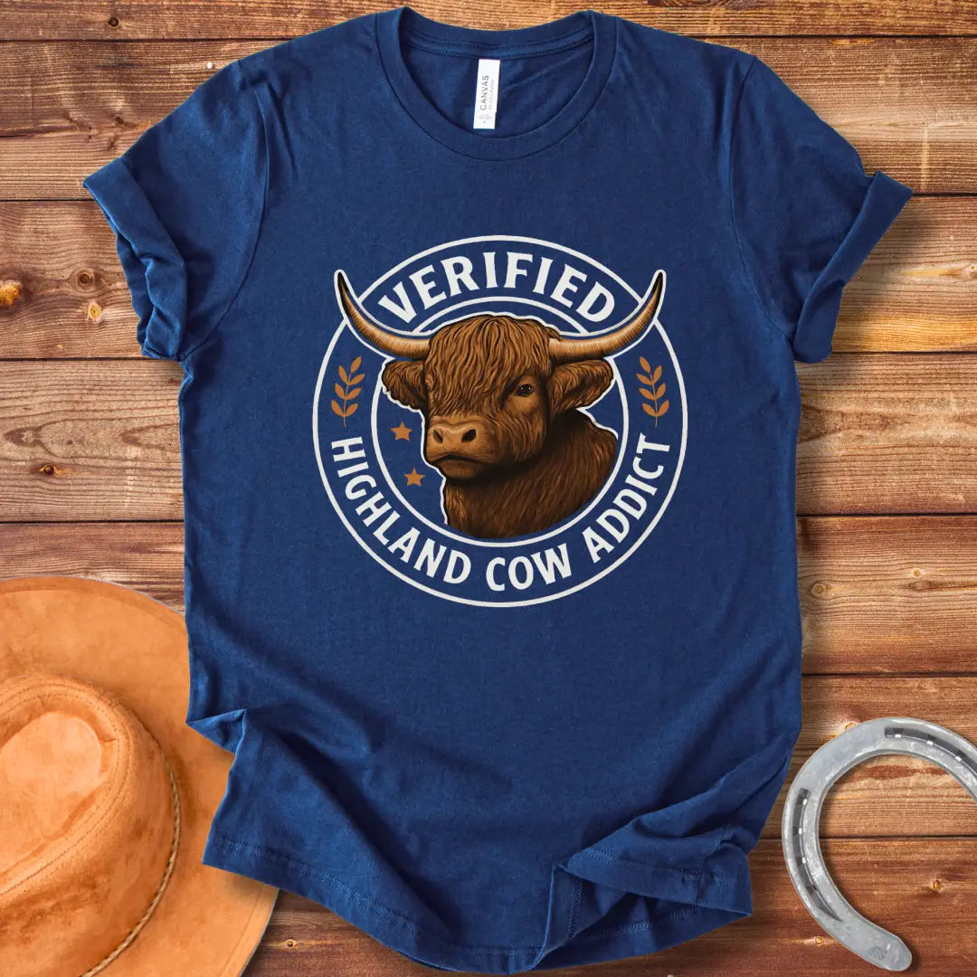 Verified Highland Cow Addict T-Shirt featuring a detailed illustration of a Highland cow in a circular design with the words 'Verified Highland Cow Addict'