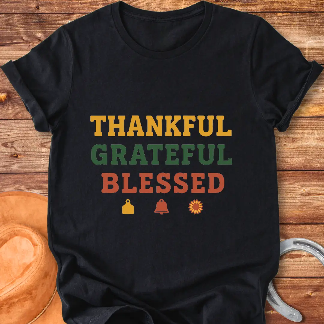 Thankful, Grateful, Blessed T-shirt with farm-themed elements like a cow tag, bell, and sunflower.