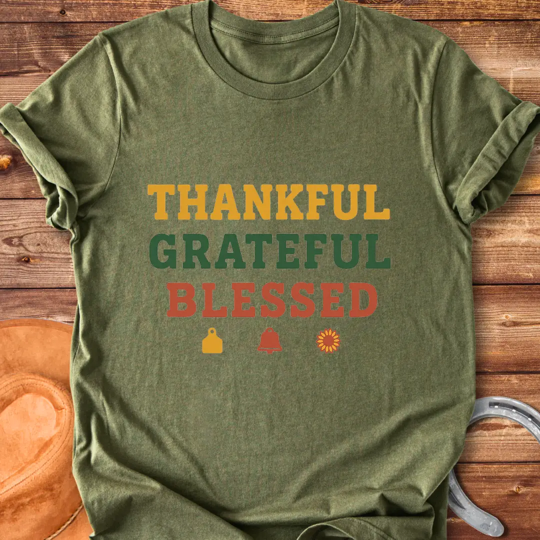 Thankful, Grateful, Blessed T-shirt with farm-themed elements like a cow tag, bell, and sunflower.