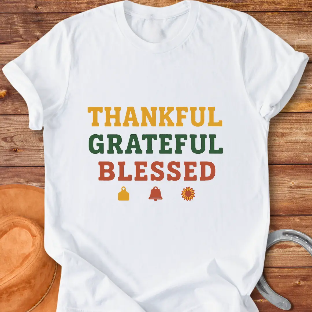 Thankful, Grateful, Blessed T-shirt with farm-themed elements like a cow tag, bell, and sunflower.