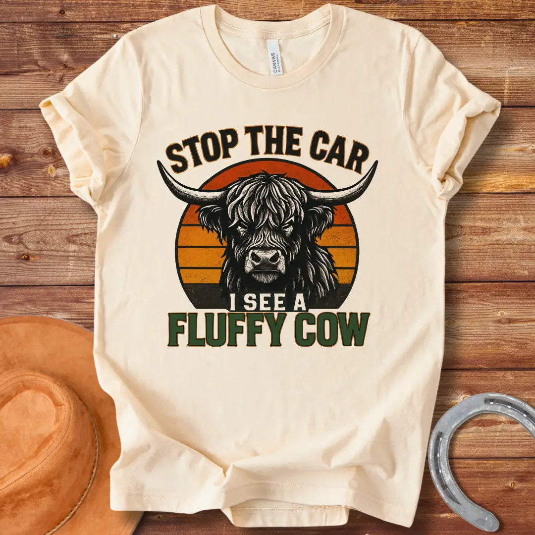 Vintage t-shirt featuring a Highland cow with the text 'Stop the Car, I see a fluffy cow' in a retro style.