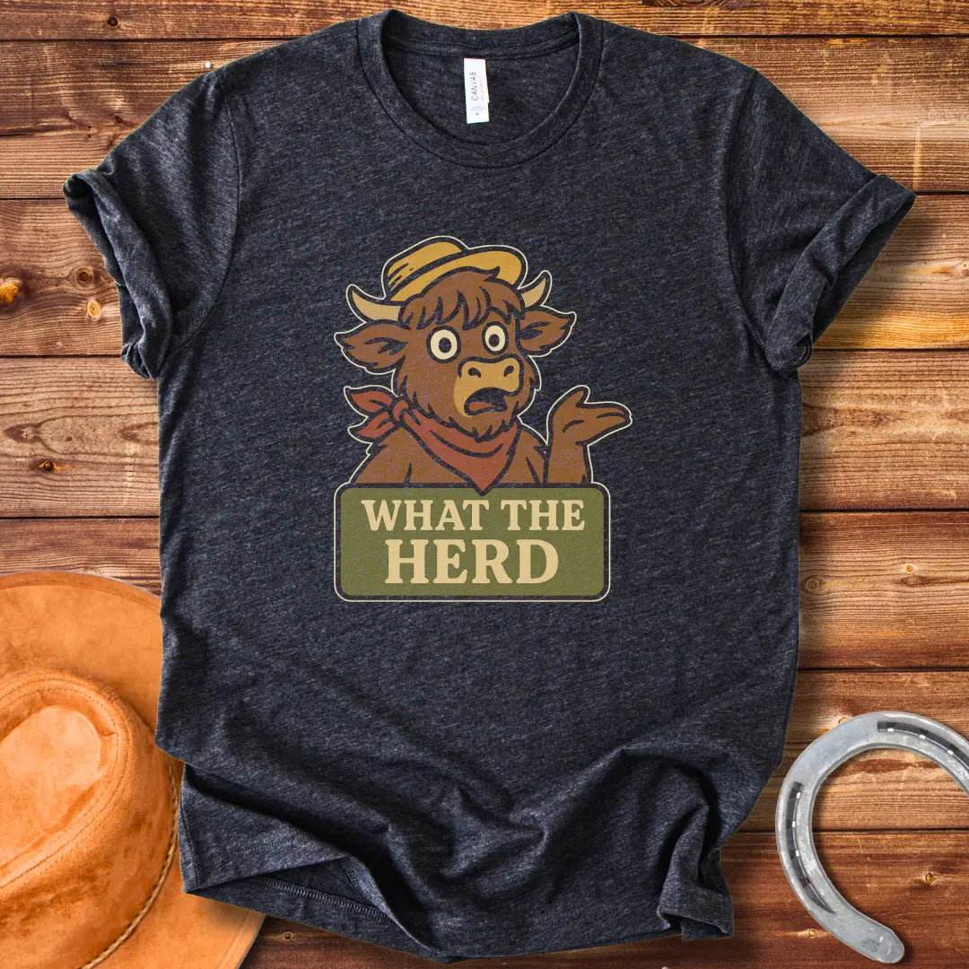 Funny t-shirt design featuring a surprised cow with the words 'What The Herd?' on a sign.