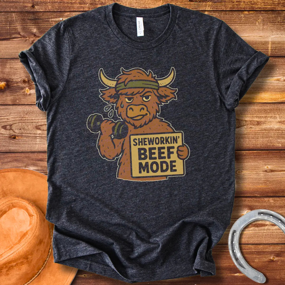 Cartoon cow working out with dumbbells, wearing a headband and holding a sign that says 'Sheworkin' Beef Mode'