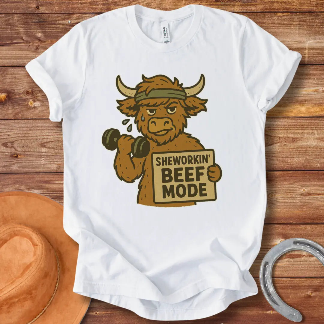 Cartoon cow working out with dumbbells, wearing a headband and holding a sign that says 'Sheworkin' Beef Mode'