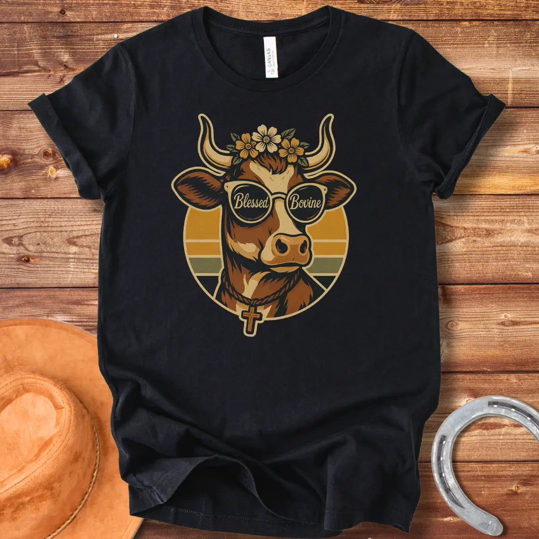 Blessed Bovine T-shirt design featuring a cow wearing sunglasses that say blessed bovine with a floral crown and a rosary.