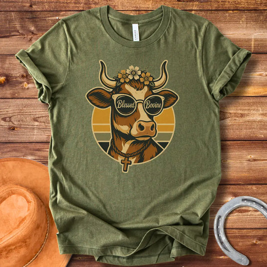 Blessed Bovine T-shirt design featuring a cow wearing sunglasses that say blessed bovine with a floral crown and a rosary.