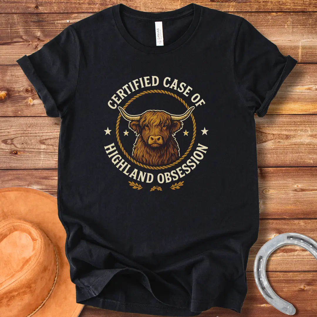 Certified Case of Highland Obsession T-Shirt featuring a detailed illustration of a Highland cow within a rope circle.